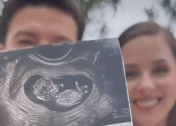 Smiling Couple Holding an Ultrasound Image of Their Developing Fetus Outdoors. - Tu Vecino Informa