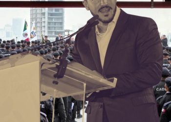Man in a Suit Speaks at a Podium in Front of a Large Crowd of Uniformed Cadets. - Tu Vecino Informa