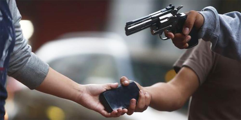 a Street Robbery Scene with a Person Handing over a Smartphone While Another Person Points a Revolver at Them. - Tu Vecino Informa