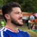 Man with Beard in a Blue Jersey Outdoors; Circular Inset Shows a Crowd Lifting an Orange-clad Teammate in Celebration. - Tu Vecino Informa